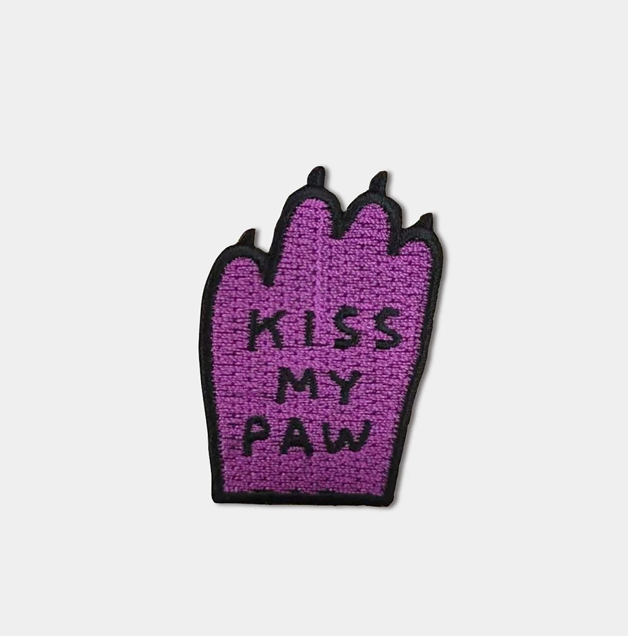 David-Shrigley- paars opstrijkembleem met de tekst 'Kiss My Paw'